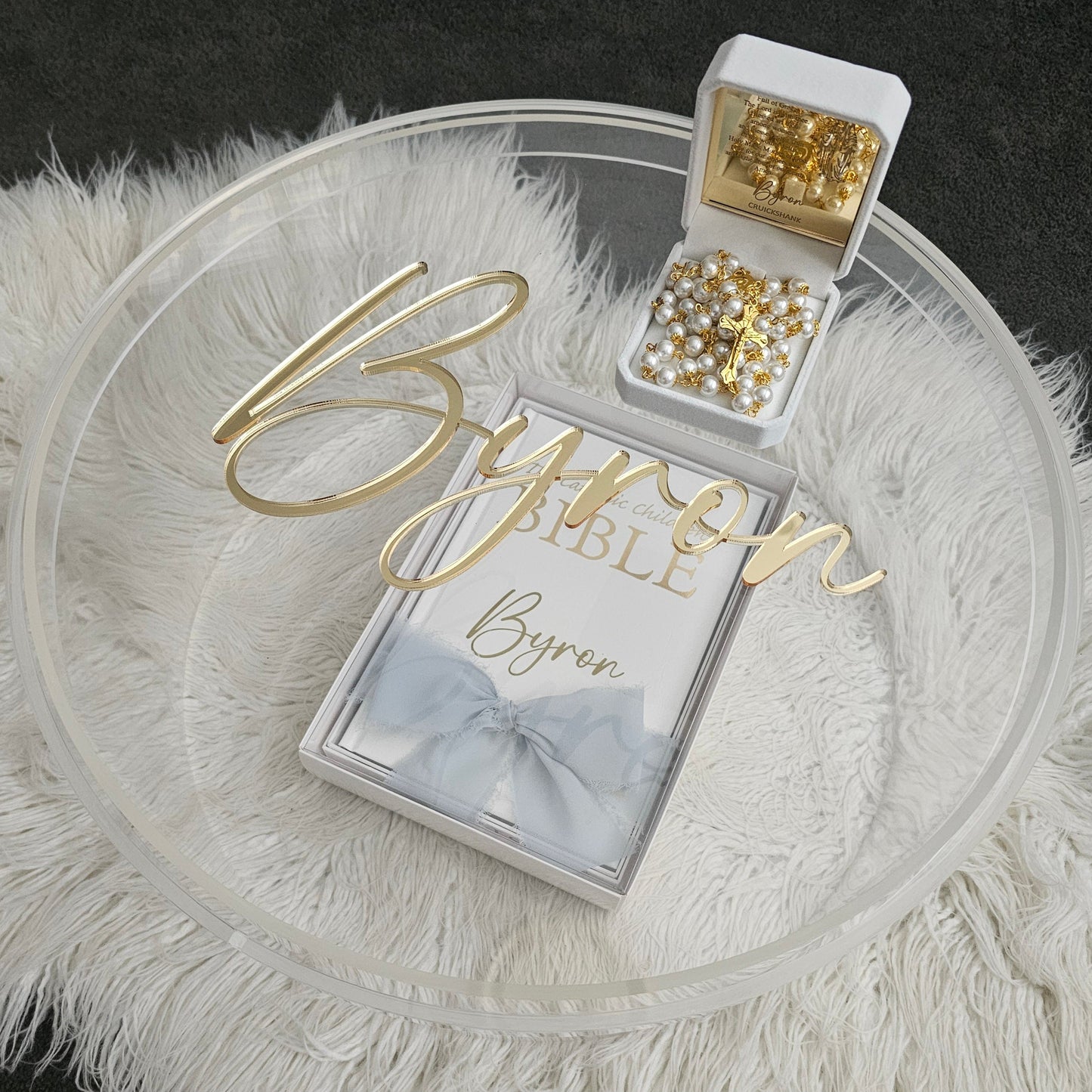 Luxury personalized gift set featuring a custom gold acrylic name plaque, personalized Bible, rosary beads, and a clear acrylic keepsake box – perfect for special occasions.