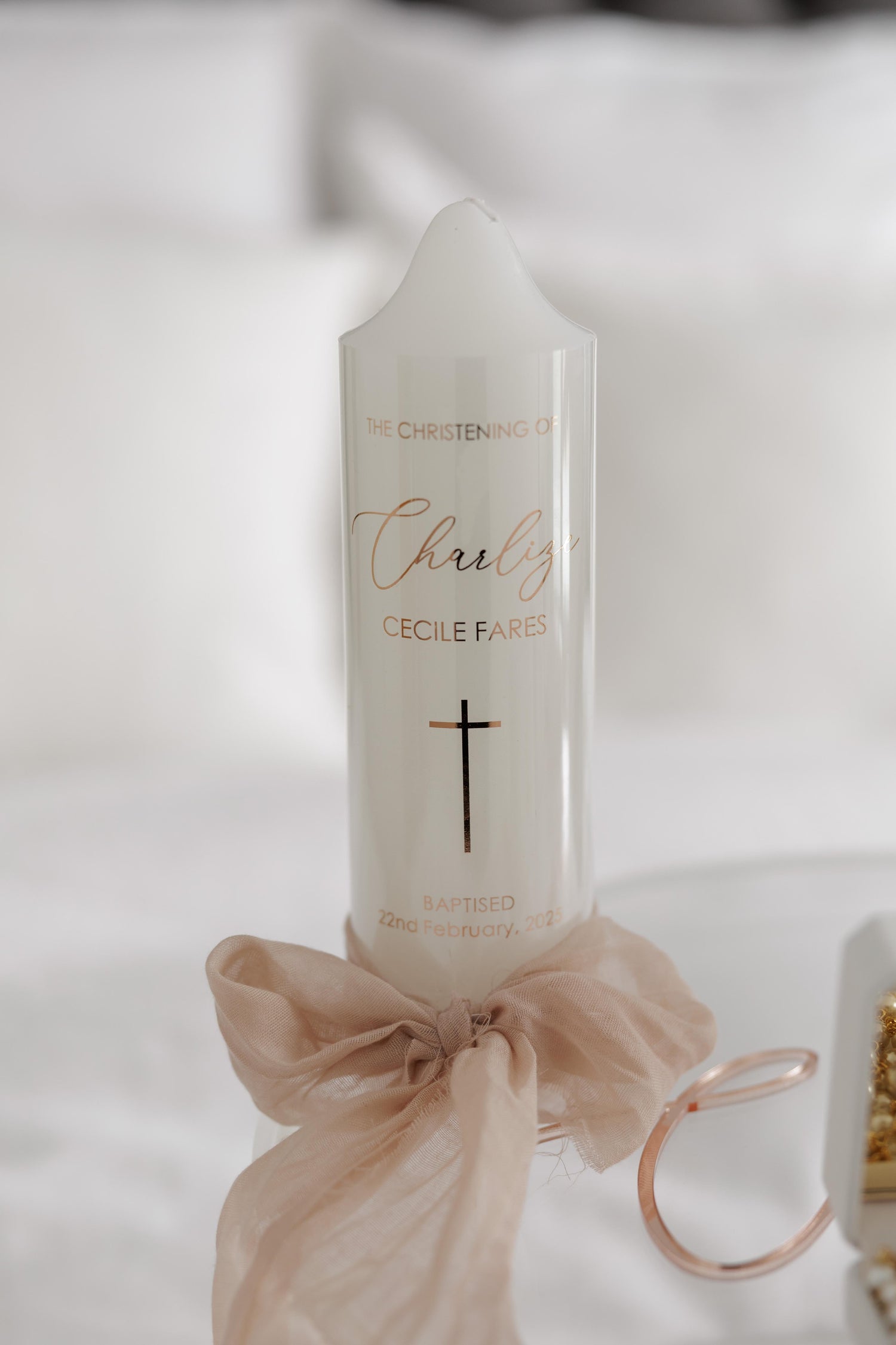 A beautifully designed personalized printed candle with elegant detailing, displayed alongside keepsakes and ceremonial accessories, perfect for weddings, baptisms, and special occasions.