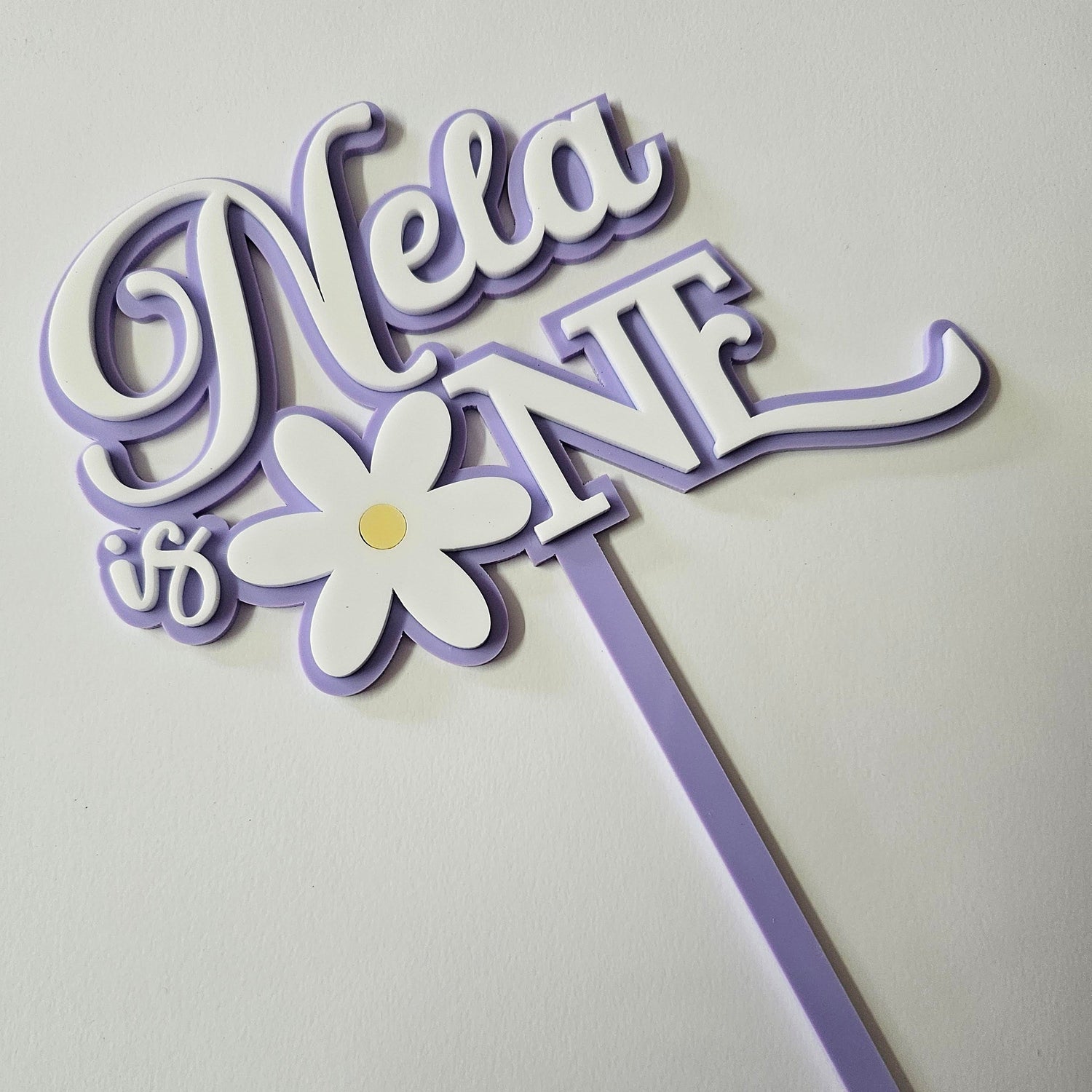 Acrylic name sign with daisy flower detail, featuring cursive and block lettering in pastel tones with purple outline