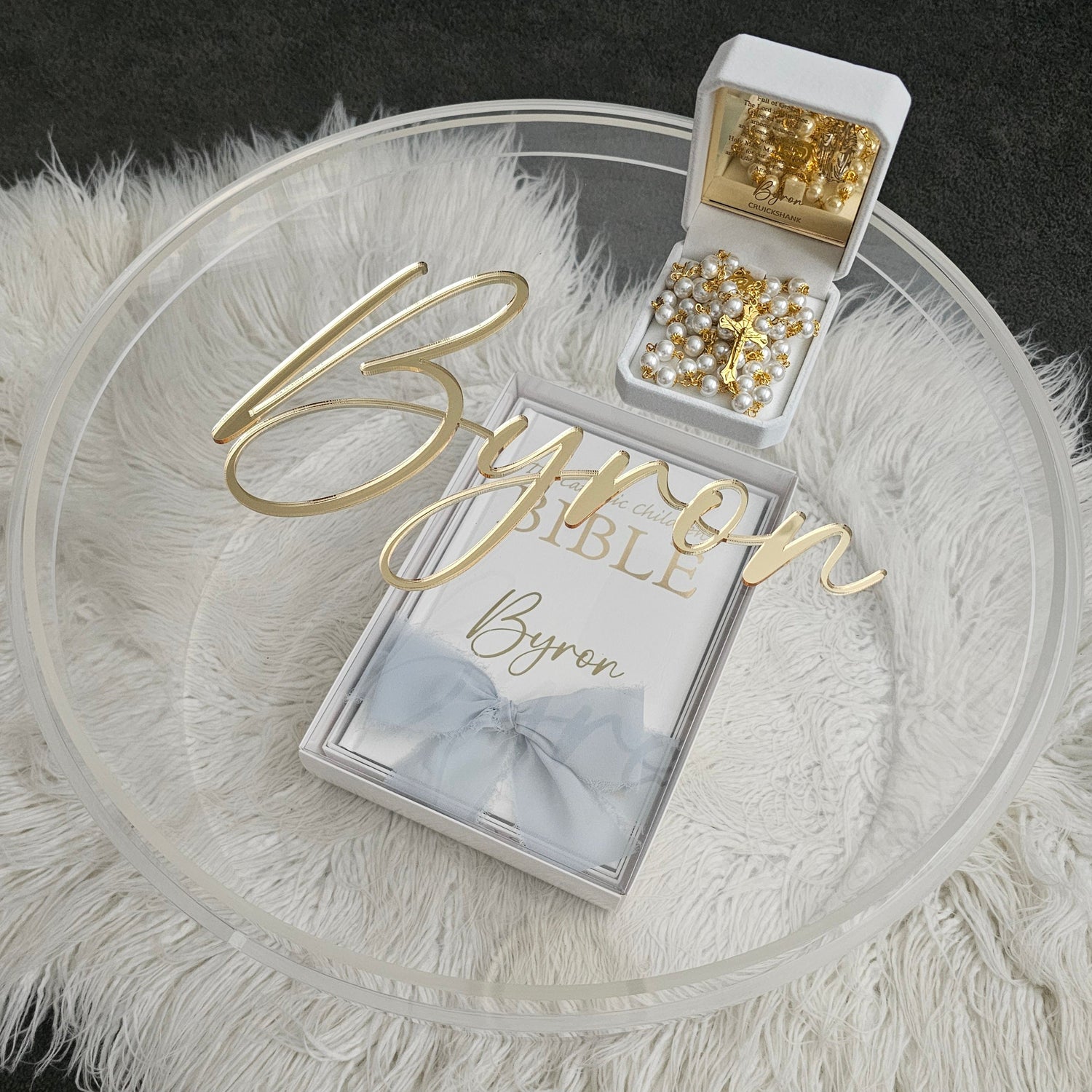 Luxury personalized gift set featuring a custom gold acrylic name plaque, personalized Bible, rosary beads, and a clear acrylic keepsake box – perfect for special occasions.