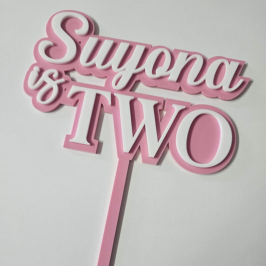 Custom "Suyona is Two" acrylic cake topper with stylish script, perfect for second birthday celebrations and milestone events.