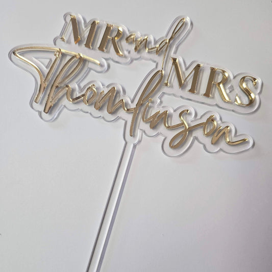 Elegant gold mirror acrylic Mr. & Mrs. wedding cake topper with custom last name, designed for a stylish and personalized touch on any wedding cake.