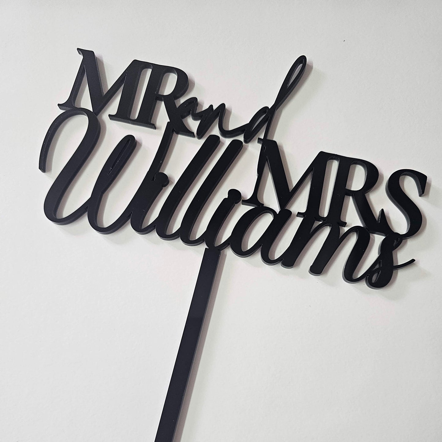 Custom  acrylic "Mr. & Mrs." wedding cake topper with a personalized last name, ideal for weddings, anniversaries, and engagement celebrations.