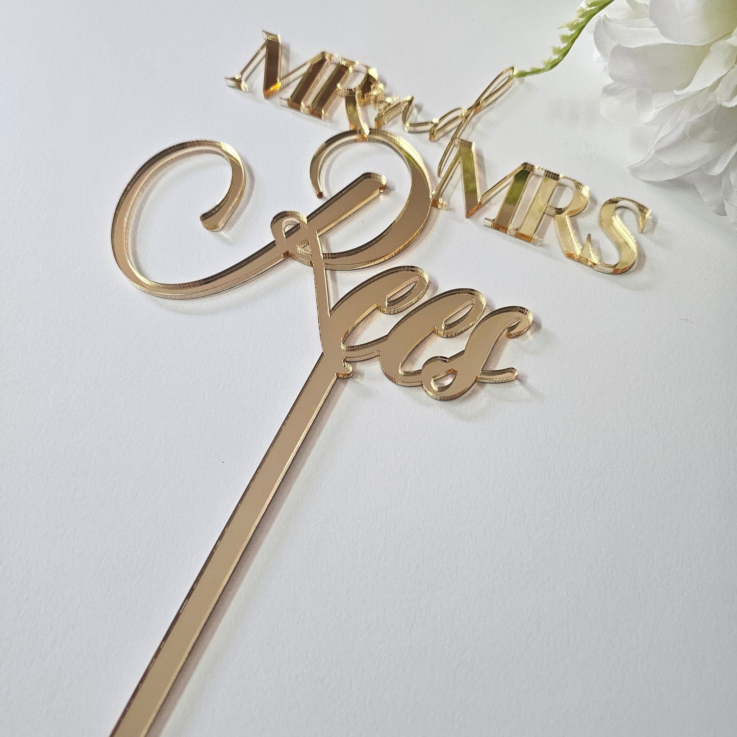 Custom  acrylic "Mr. & Mrs." wedding cake topper with a personalized last name, ideal for weddings, anniversaries, and engagement celebrations.