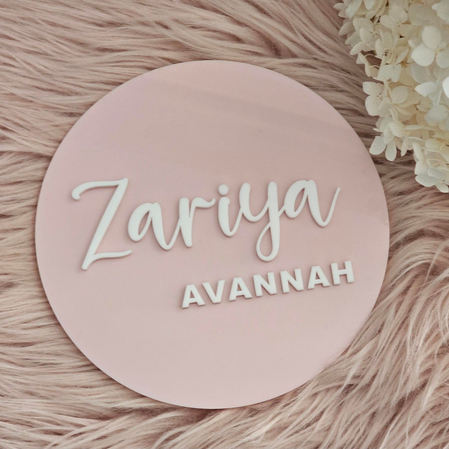 Round baby name plaque with pink background featuring mixed fonts 
