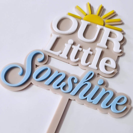 "Our Little Sonshine" double-layer acrylic cake topper featuring white and baby blue text, a bright yellow sun, and a beige background, perfect for baby showers and first birthdays.