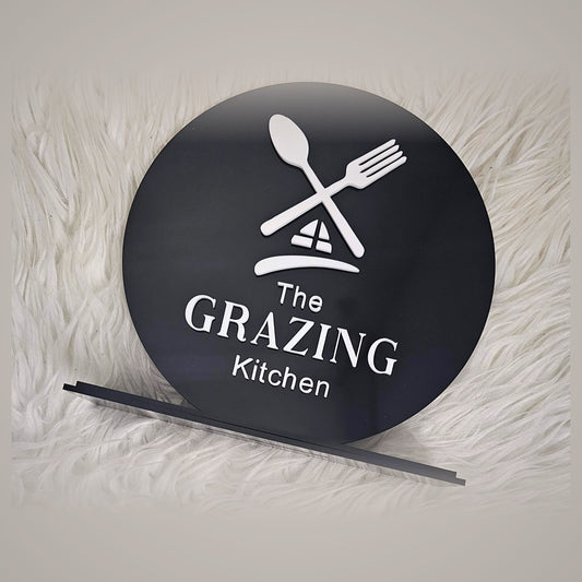 Round black acrylic custom business logo sign with freestanding stand for cafe or shop counter