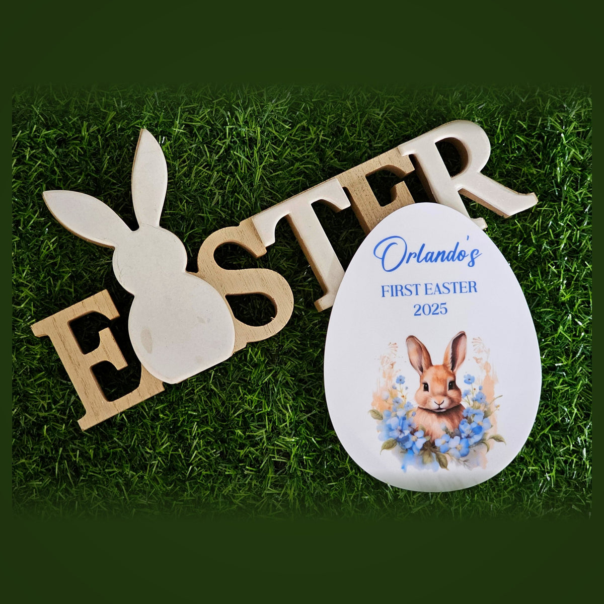 Egg shaped personalised First Easter plaque with bunny illustration styled on grass