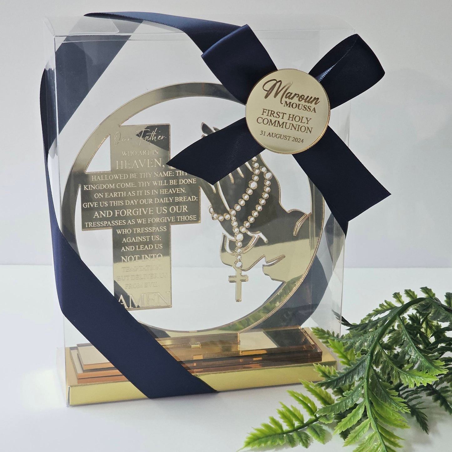 Gold mirror acrylic bomboniere with praying hands, engraved Lord’s Prayer, and personalised Communion tag with navy ribbon