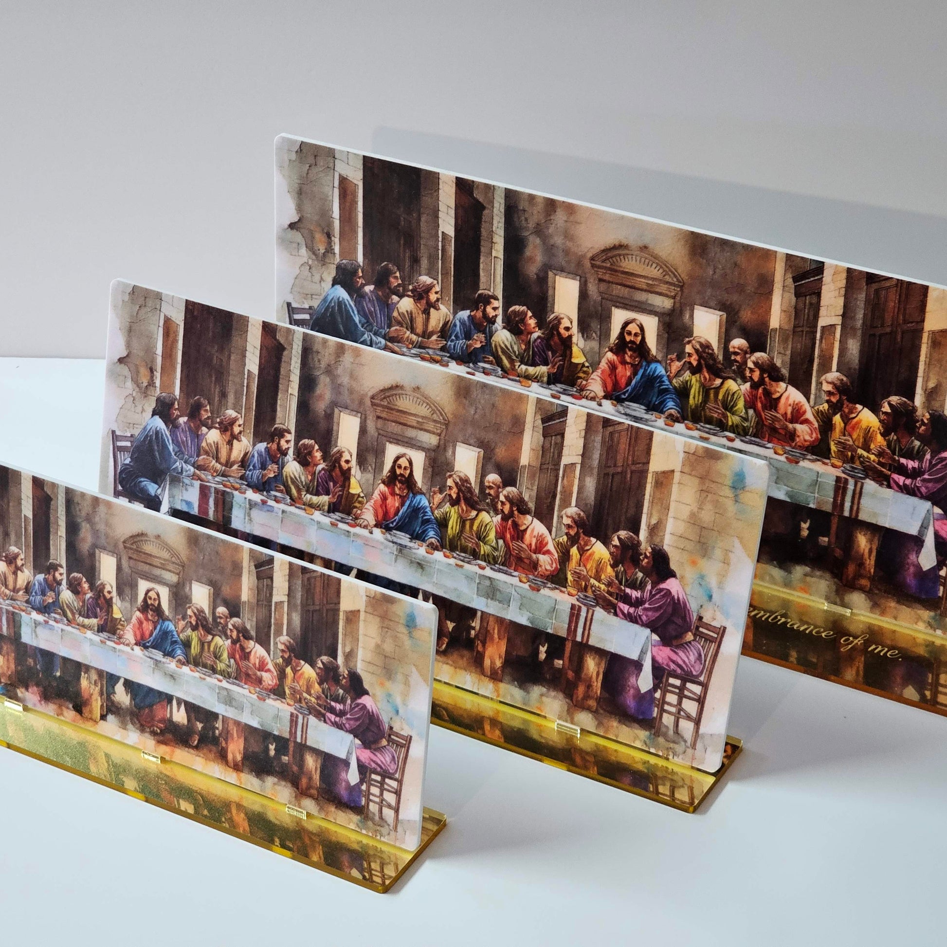 Three sizes of The Last Supper acrylic display — 20cm, 25cm, and 30cm — UV-printed artwork with mirror-gold base engraved with Luke 22:19 scripture