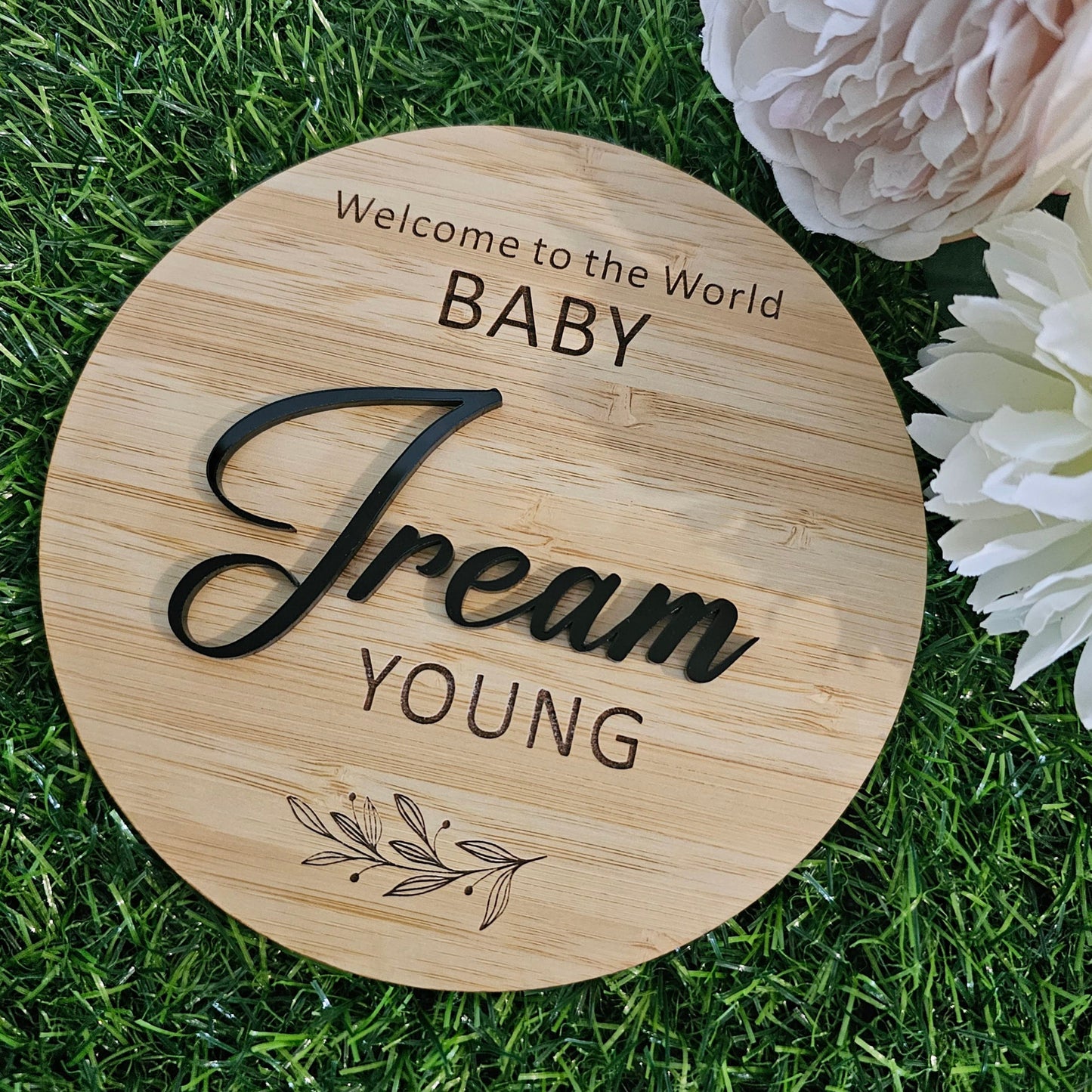 Personalised bamboo baby name plaque with black acrylic lettering and engraved “Welcome to the World” design — handmade newborn keepsake